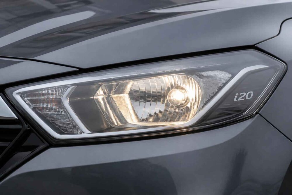 Zbliżenie na przedni reflektor samochodu Hyundai i20 w szarej karoserii